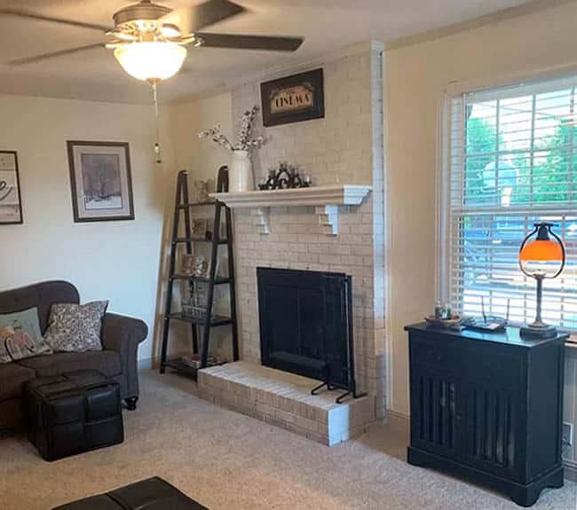 Ceiling fan with lighting fixture, ladder shelf, grey couch and window