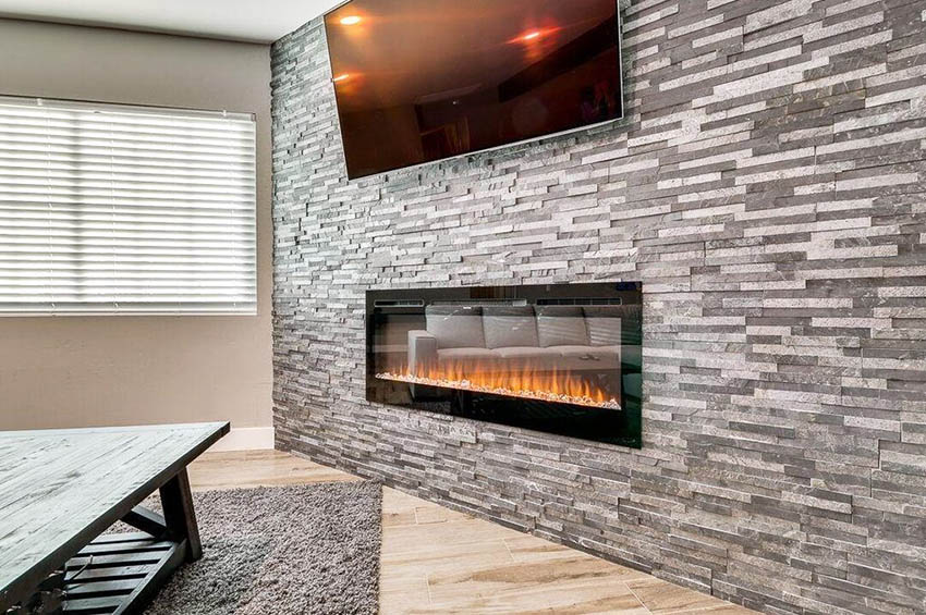 Living room with gray stacked stone accent wall with gas fireplace