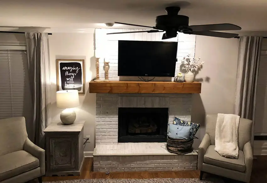 Room with fireplace. lampshade and television above fireplace