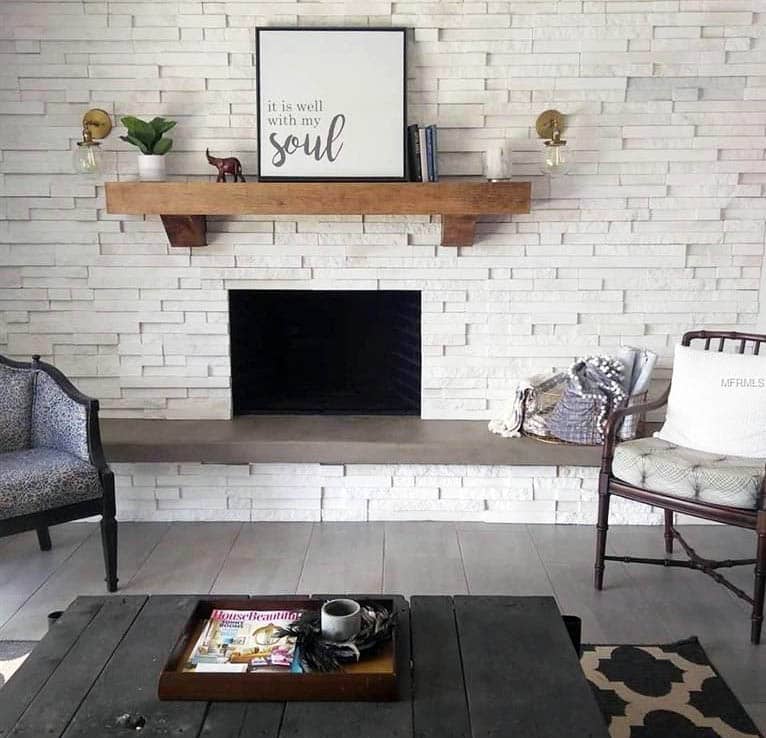 Living room with white stacked stone accent wall with fireplace