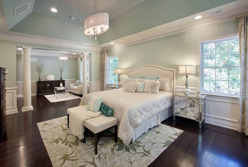 Master bedroom with dark brown wood flooring and mint green paint and wallpaper