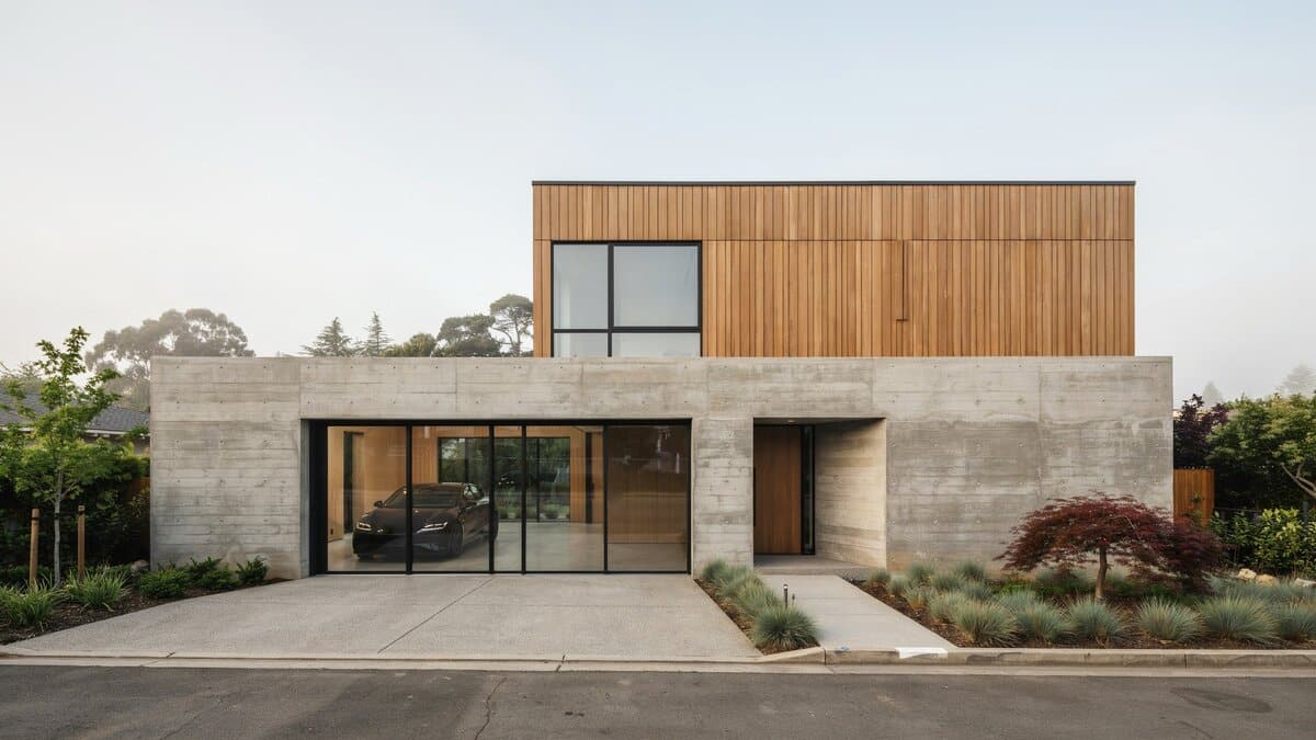 Flat roof modern home showing a full glass garage door in black frame