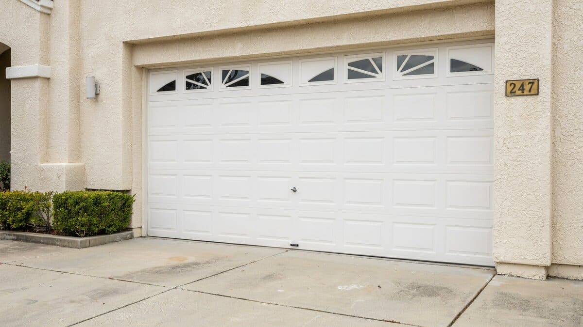 White sectional door with four rows of raised panels and arched inserts