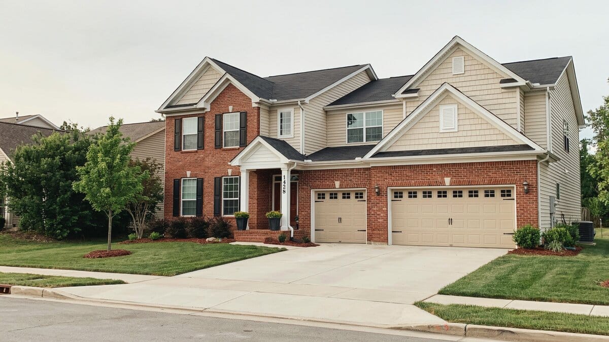 Traditional home fronted by two separate almond single bay doors