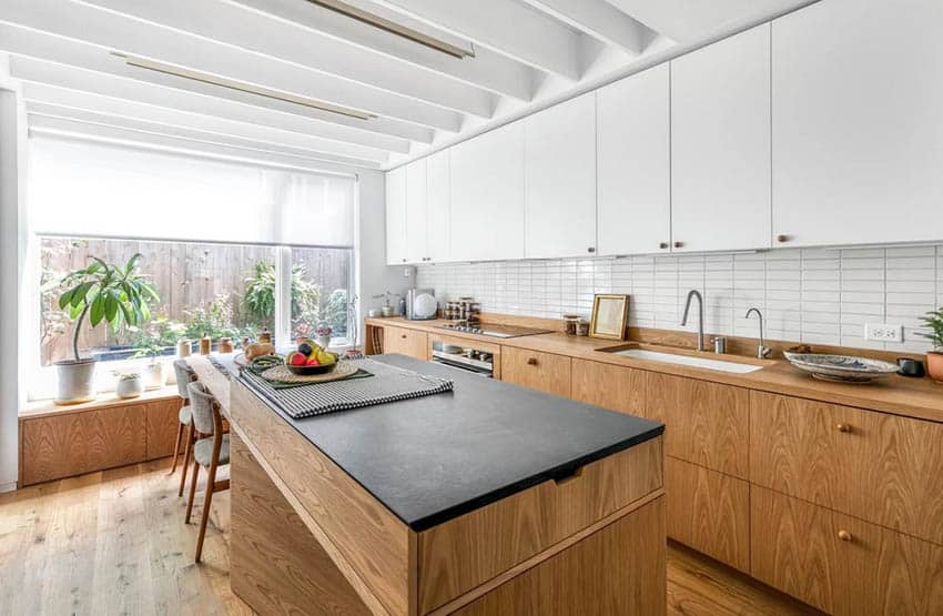 Kitchen with 4 inch wood backsplash, wood cabinets and countertops with white tile backsplash