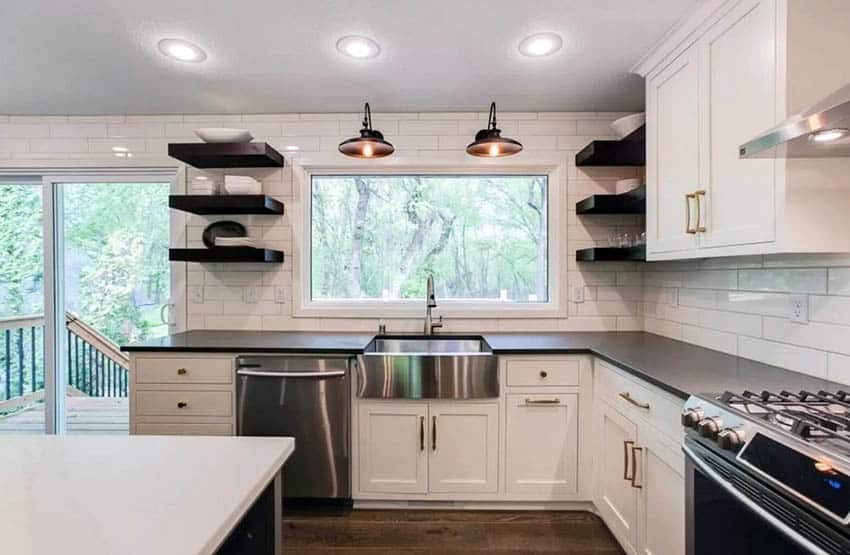 Kitchen with black open shelving long subway tile and white cabinets