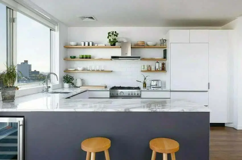 Kitchen with marble top peninsula, wood stools and picture window