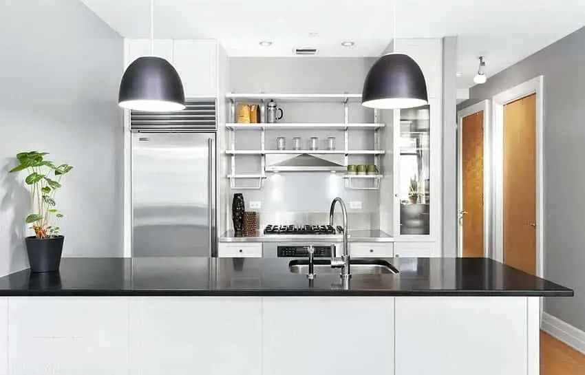 Kitchen with shelves with metal racks and black quartz peninsula
