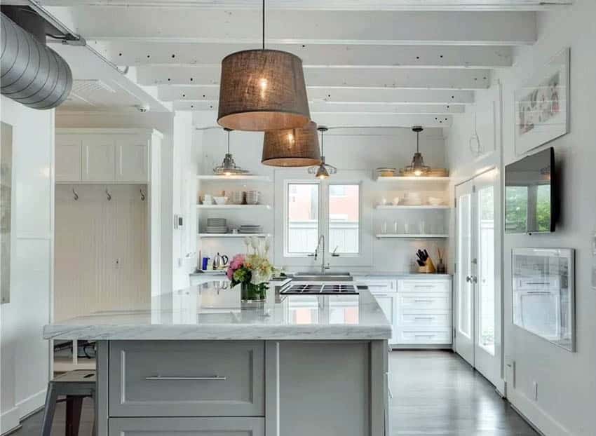 Kitchen with white cabinets open shelving island wood beams