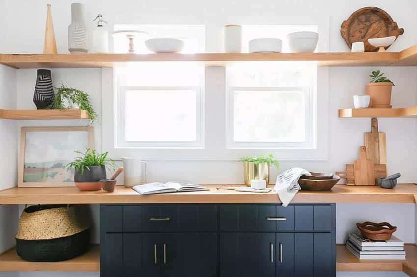 Kitchen with wood open shelving above window sink and black base cabinets