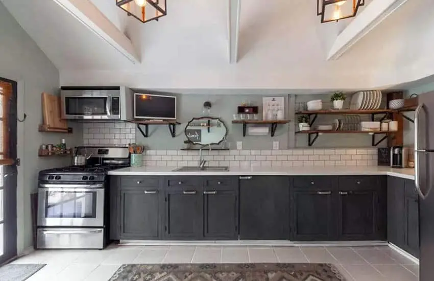 L shaped kitchen with dark lower cabinets
