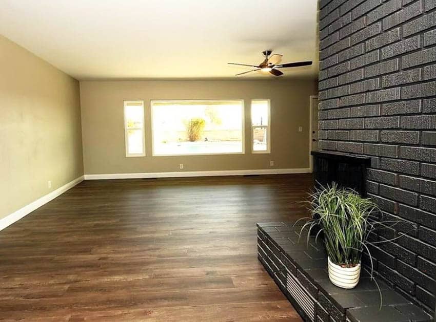 Large living room with painted black brick fireplace