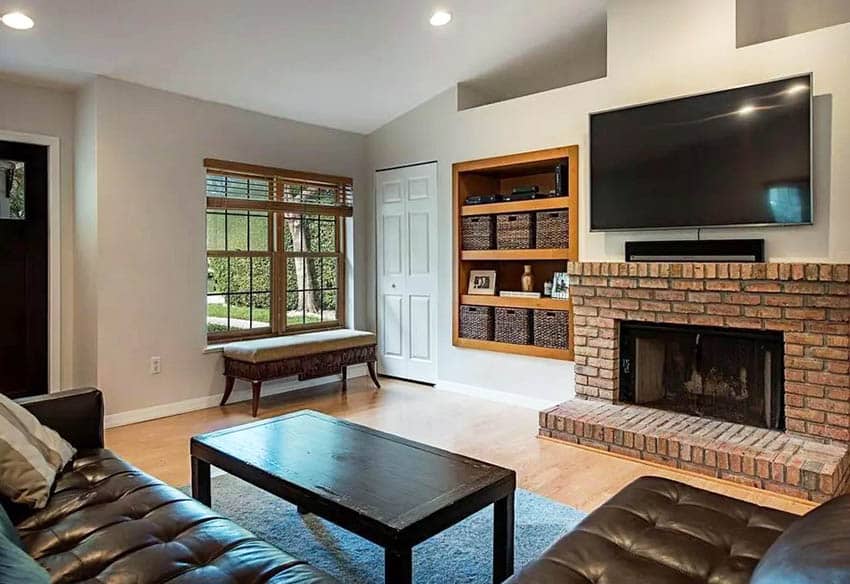 Living room with brick fireplace and wall alcove with storage