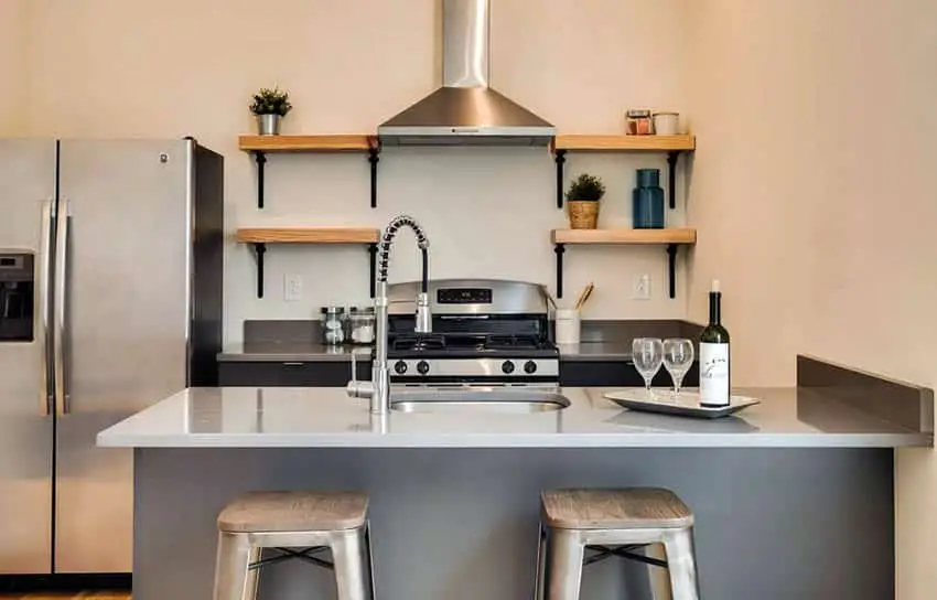 Kitchen with grey island, solid surface countertops and oak kitchen shelves