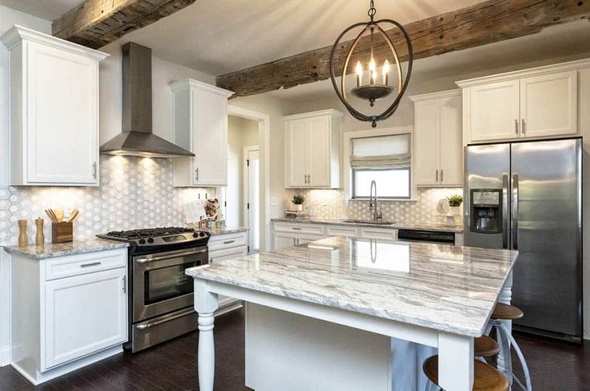 Remodeled kitchen with white painted cabinets quartz countertop island with legs and tile backsplash