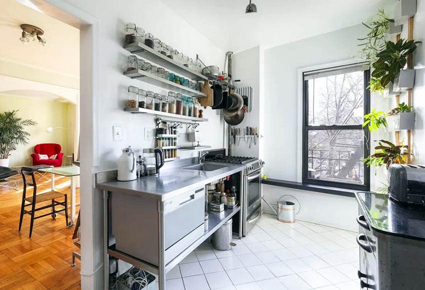 Small kitchen with open shelving glass jars stainless steel countertops