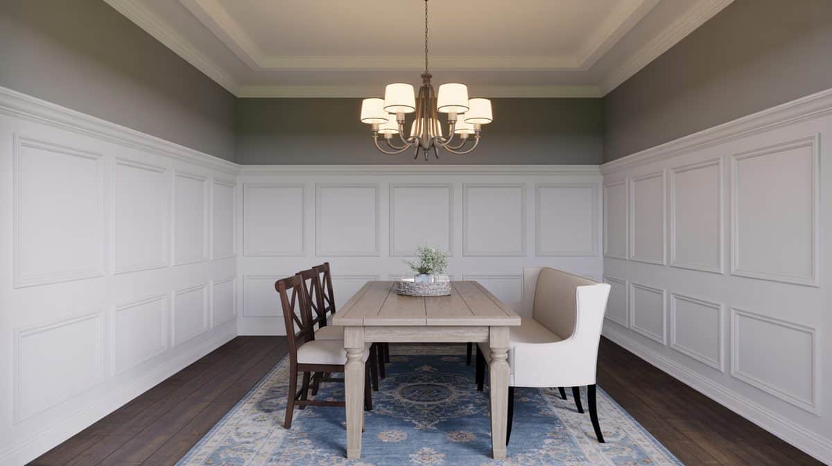 Gray dining room with white flat panel wainscoting encircling all walls, farmhouse trestle table, blue Persian rug, and tiered drum chandelier