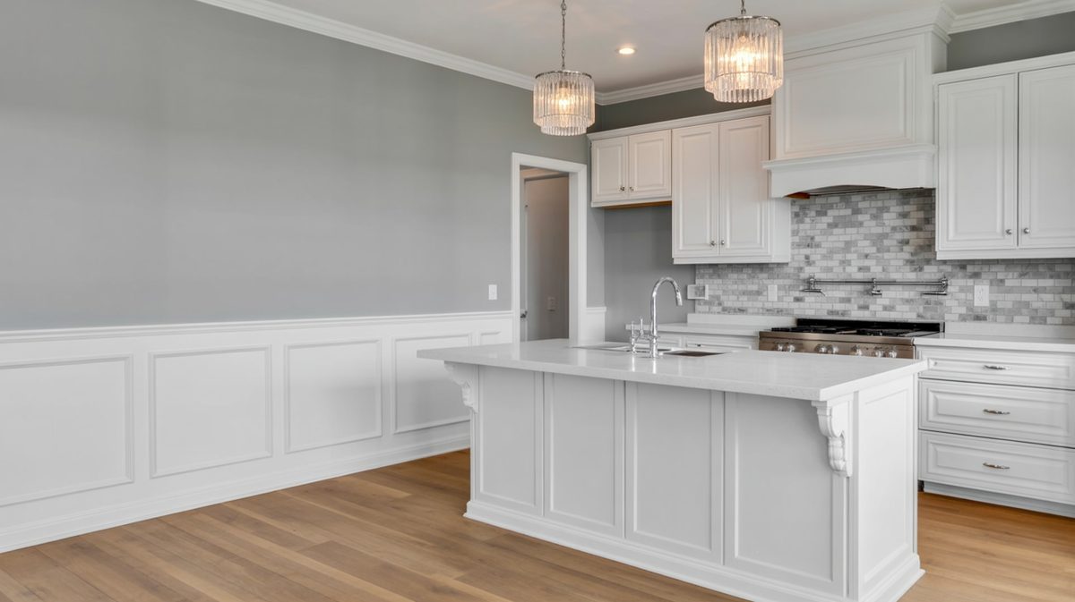 Bright kitchen with white flat panel treatment in the eating area, large center island, white shaker upper cabinets, and gray marble mosaic backsplash