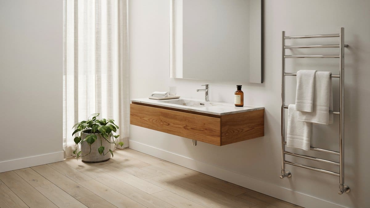 Chrome heated towel rack beside a floating walnut vanity with marble counter
