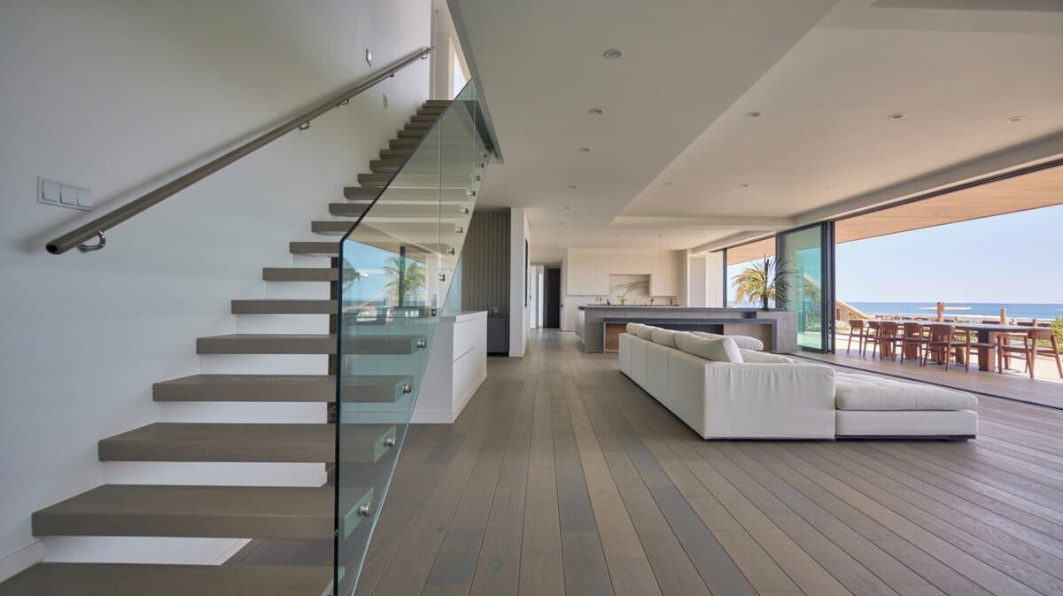 Beachfront modern home with floating oak stairs and frameless glass balusters with ocean view