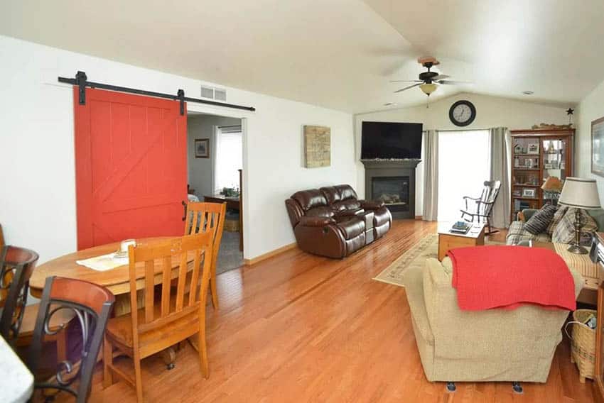 Red door, chairs, fireplace in grey finish and cabinet with glass front