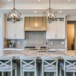 Contemporary kitchen with running bond tile with inlay over oven