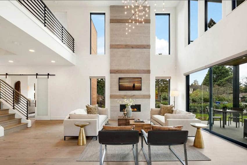 Room with two couches, sliding glass doors and staircase with black railings