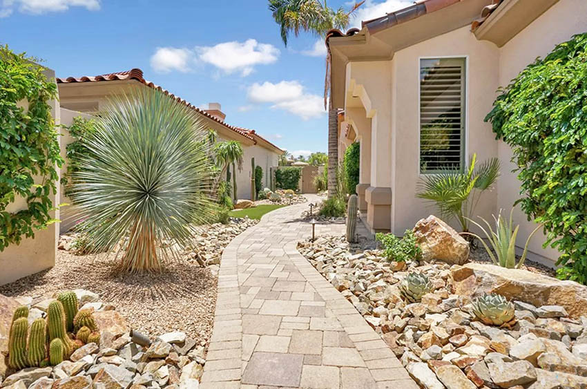 House with desert landscaping paver path cactus and rocks