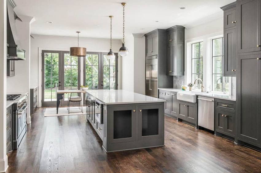 Kitchen with dark gray cabinets, hardwood flooring and pendant lights