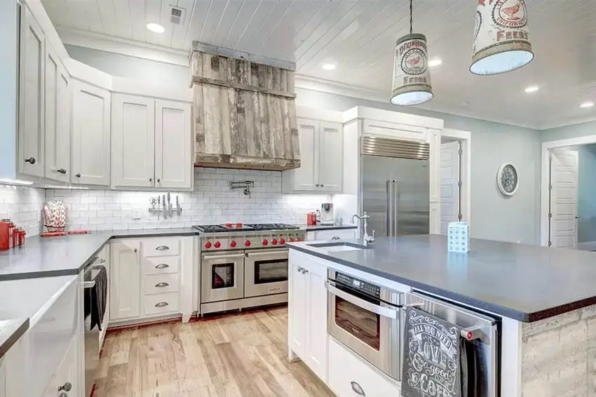 Kitchen with shiplap ceiling, white cabinets and wood flooring