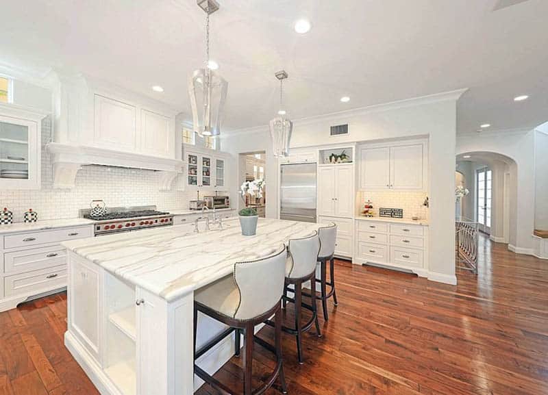 Kitchen with white cabinets and calacatta gold honed marble countertops