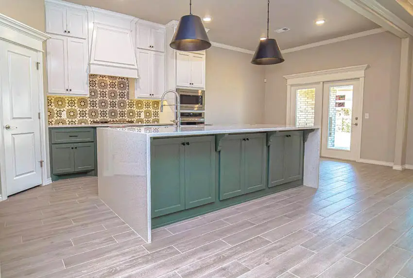 Kitchen with wood look tile flooring white cabinets and green island