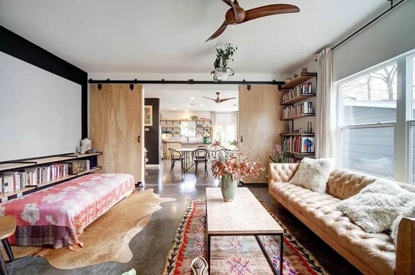 Room with maple doors, bookshelf and tufted couch