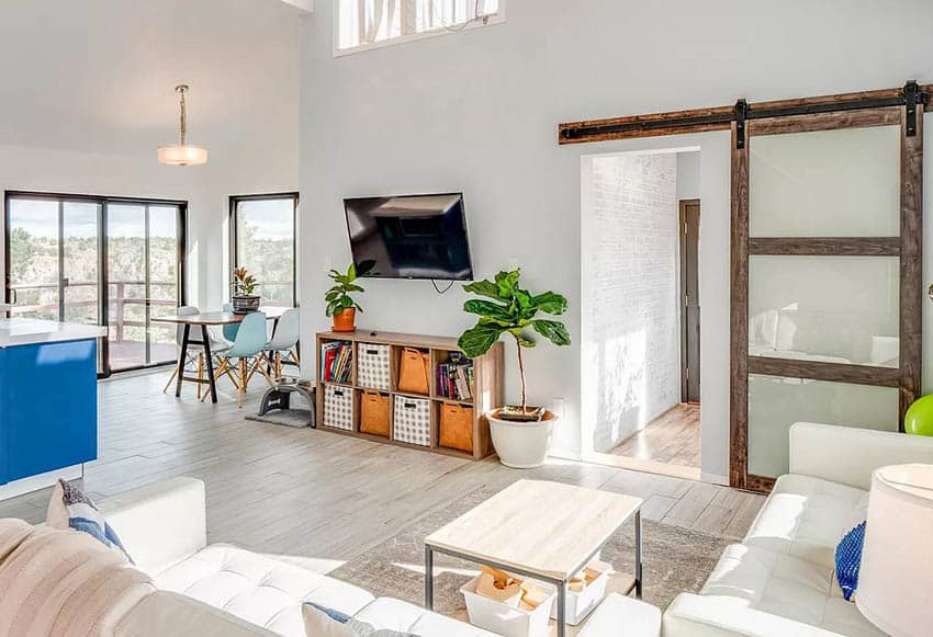 Door with frosted glass, white table, sectional and blue island