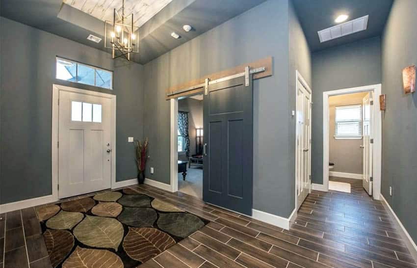Living room with dark gray painted sliding barn door to bedroom