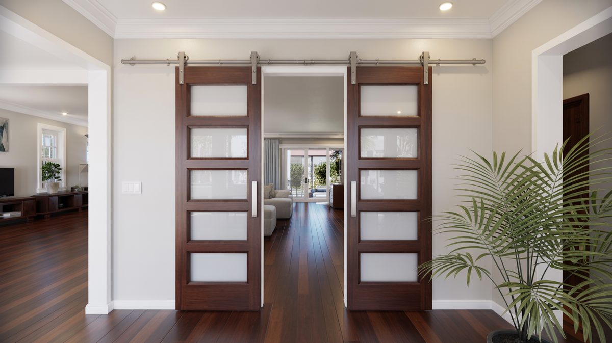 Five-panel frosted glass walnut barn doors on brushed nickel rail in a bright hallway with rich dark hardwood floors and a tropical palm plant