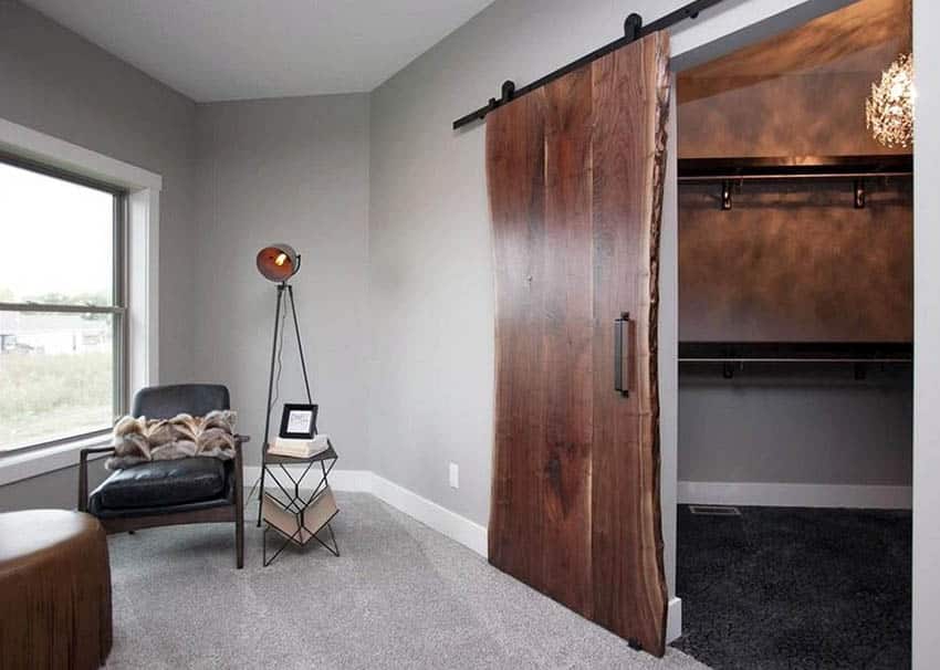 Door made of reclaimed wood, modern side table and black leather couch 