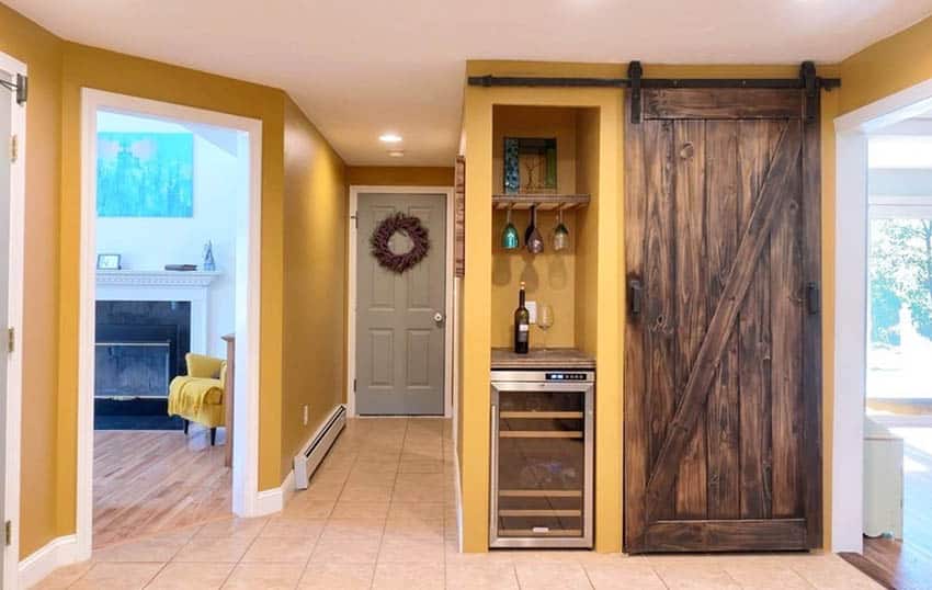 Room with yellow walls, wood door and wine chiller