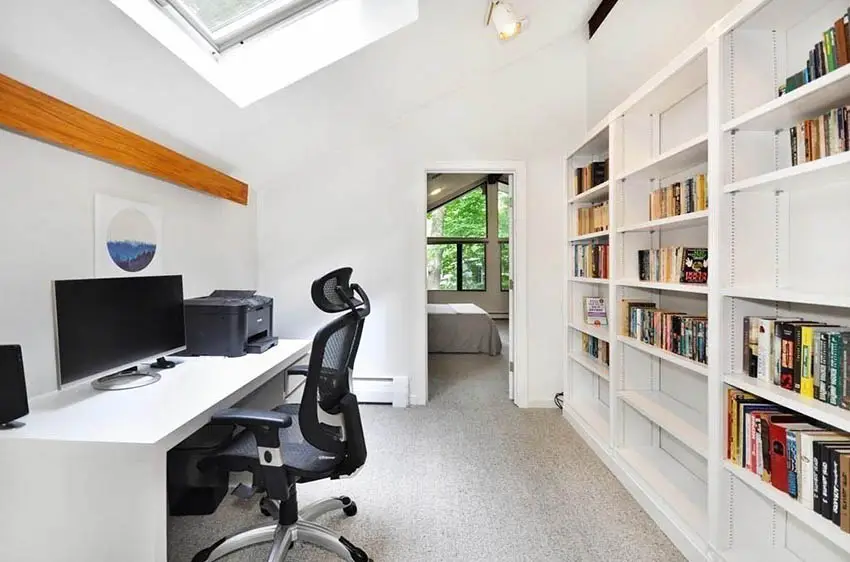 Upstairs office with skylight and wall of shelving