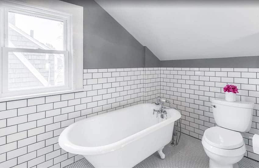 Bathroom with white penny tiles and black grout with subway tile walls