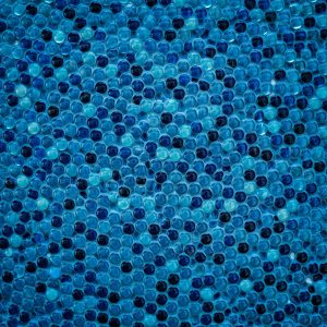 Close-up of glossy blue glass penny tiles set as a grout-free sheet