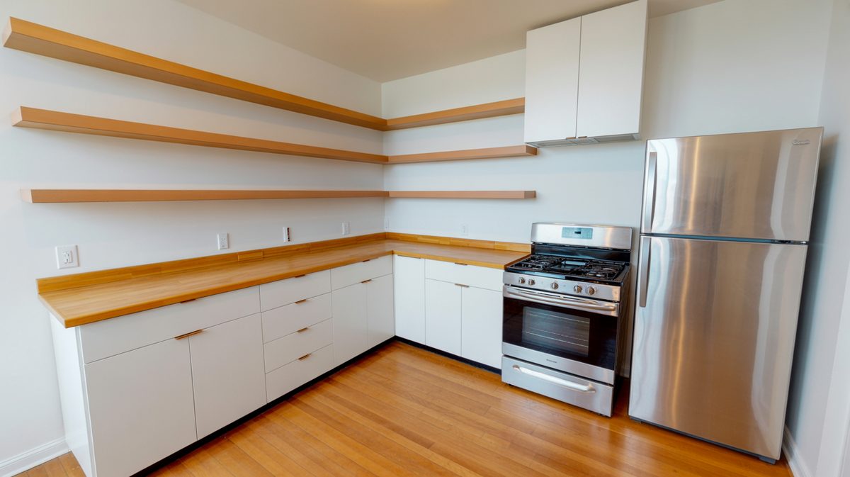 Dark modern kitchen with wood open shelves and gray peninsula sink