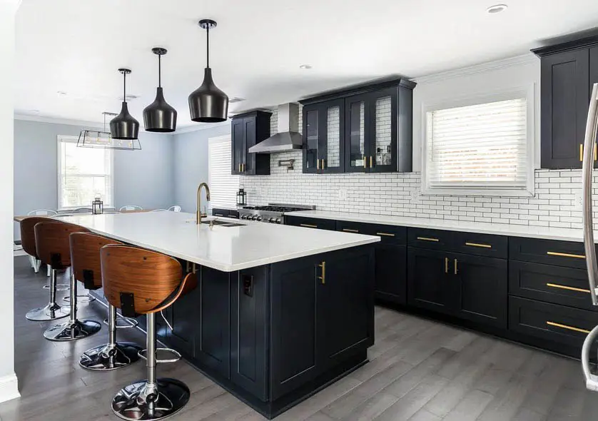 Kitchen with black cabinets and white countertops with white subway tile backsplash