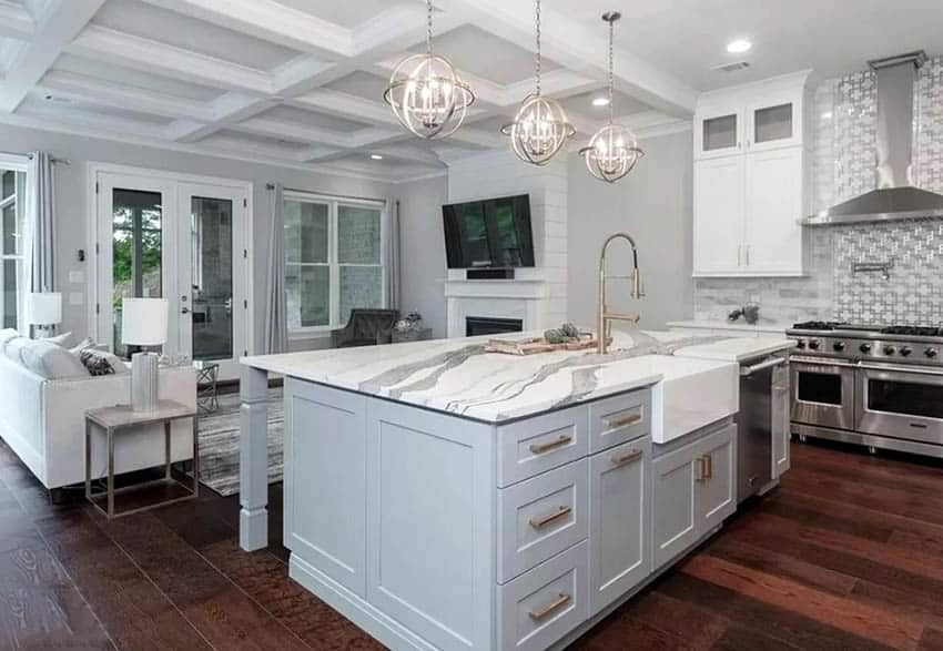 Kitchen with cambria quartz island wood flooring white cabinets