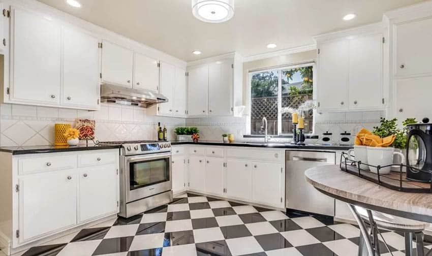 Kitchen with white cabinets black and white checkered floor tile