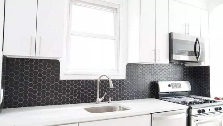 Kitchen with white cabinets black hexagon tile backsplash