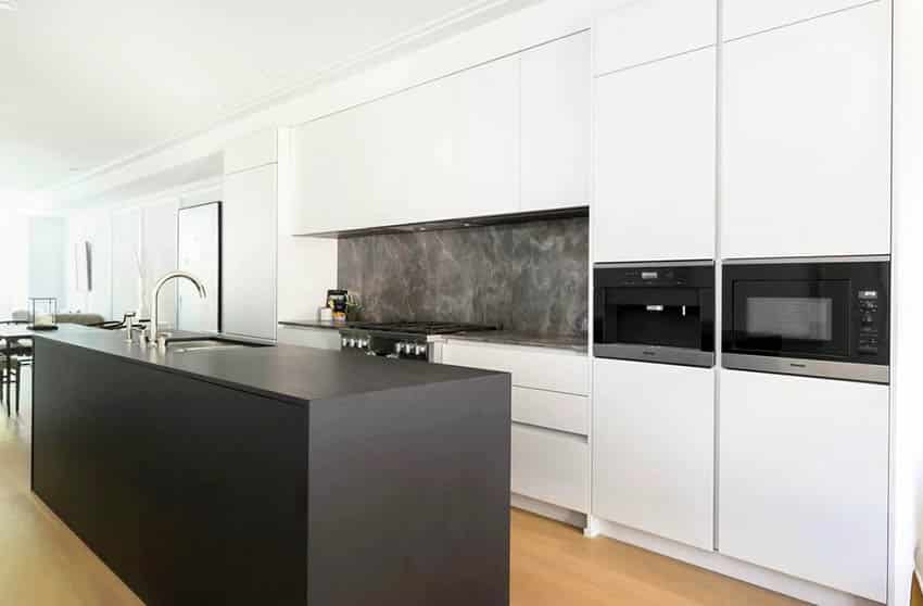 Modern kitchen with black island and white cabinets dark quartz backsplash