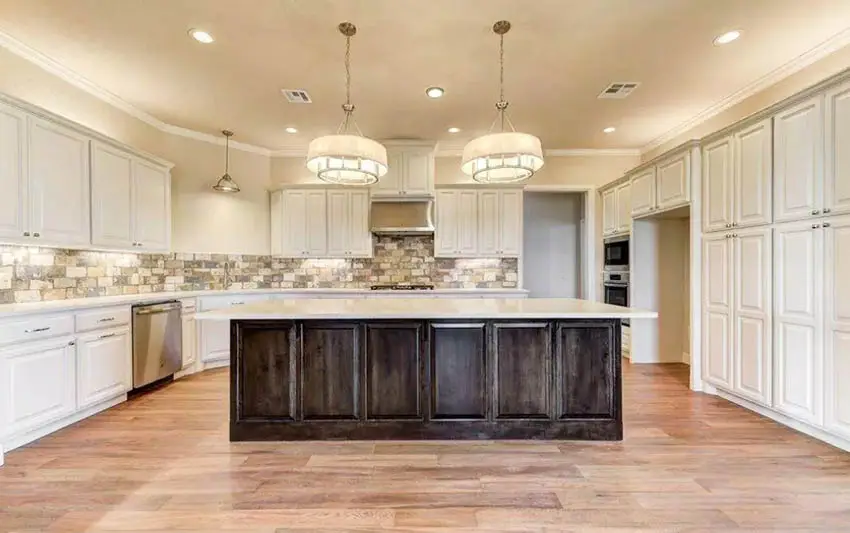 beige-kitchen-cabinets-with-dark-wood-island-brick-tile-backsplash-wood-flooring