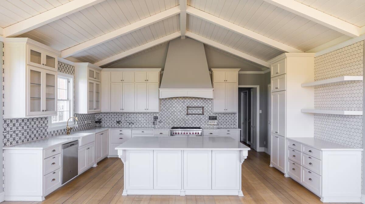 Contemporary white kitchen with vaulted tongue and groove ceiling above bold geometric tile backsplash and white island