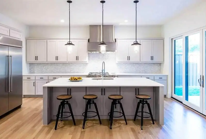 Contemporary kitchen with wall mounted oven hood, gray island and white cabinets